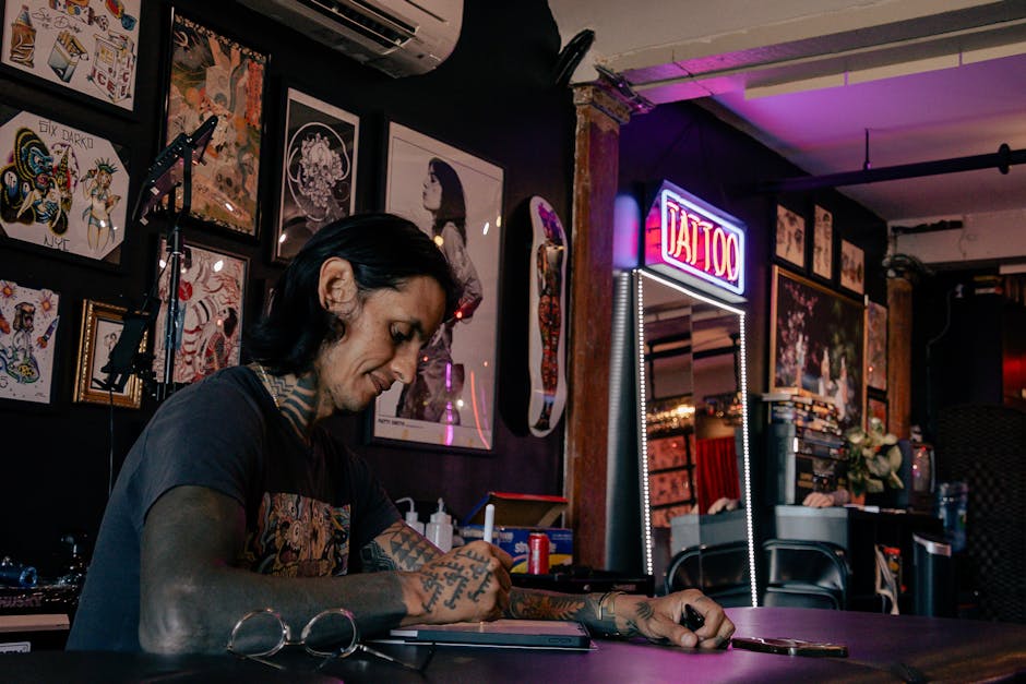 Tattoo artist sketching designs in a vibrant, urban studio setting.