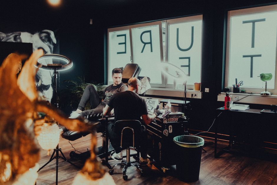 Tattoo artist creating a detailed design in a modern studio environment.