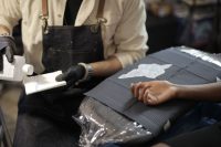 Tattoo artist in black gloves preparing a clean, wrapped workstation before a session