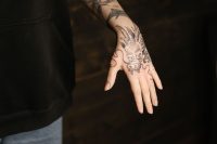 Mano con un tatuaje de dragón en tinta negra con gran detalle