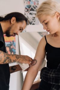 Tatuador envolviendo con film un tatuaje recién hecho para que empiece a curar