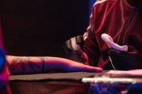 Tatuador con guantes limpiando el brazo de un cliente en el estudio
