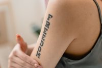Brazo de una mujer con la palabra Freedom tatuada en letras verticales