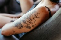 Close up of a healing floral tattoo on a woman's forearm