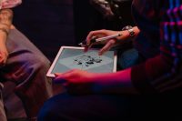 Tattoo artist sketching a tattoo design on a tablet with a stylus under neon lighting