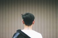 Small anchor tattoo on the back of a man's neck below his hairline