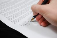 Hand signing a consent form with a fountain pen