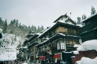 Traditional wooden buildings in a snowy Japanese onsen town