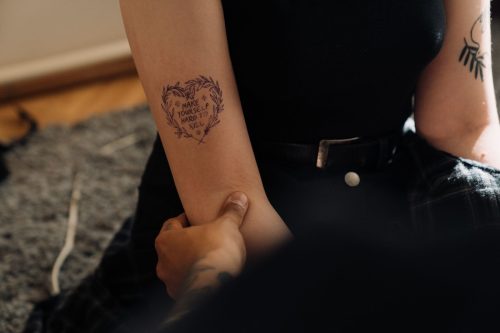 Antebrazo con un tatuaje de corazón de líneas finas